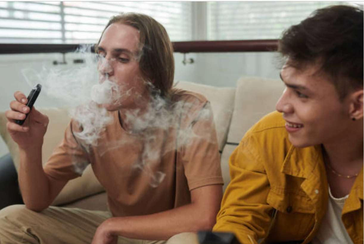 Two young men sitting on a couch during a smoke session